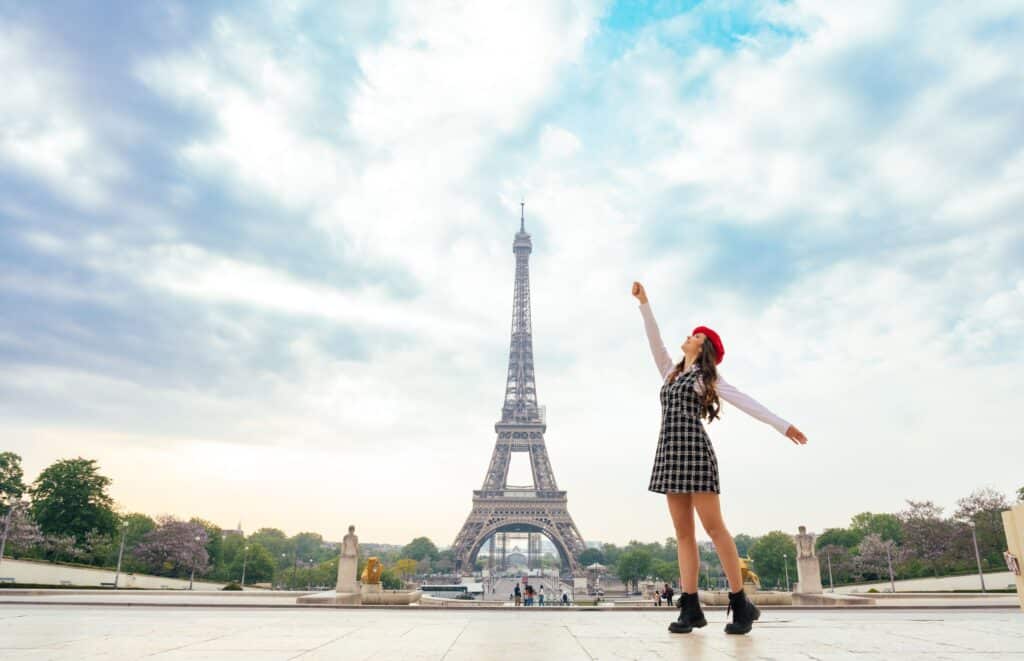 Frau mit rotem Hut vor Pariser Eiffelturm