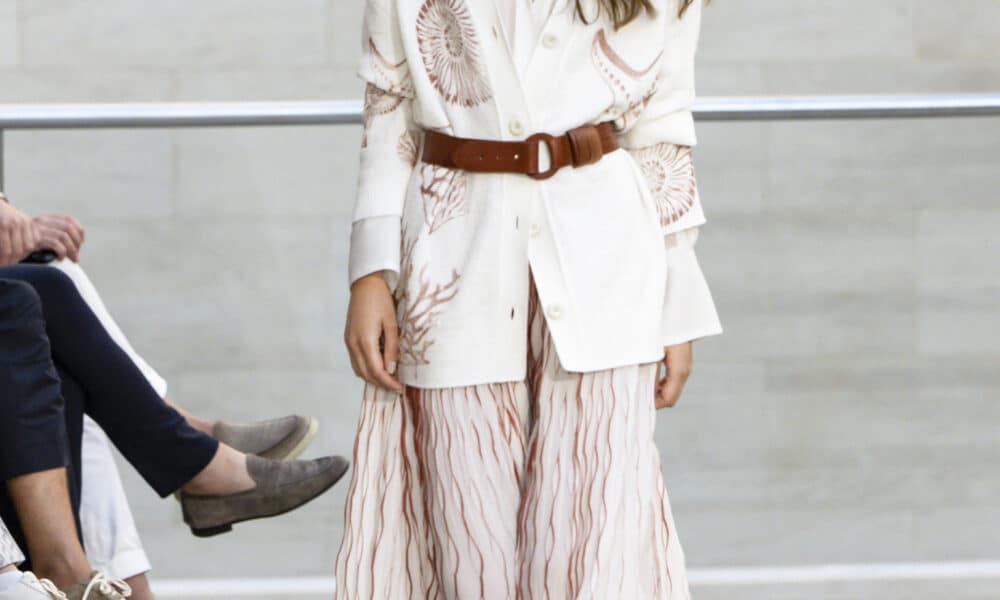 Marc Cain Frühjahr Sommer 2026 Kollektion – weisses Maxi-Ensemble mit Korallen-Print, braunem Ledergürtel und ovaler Sonnenbrille, Berlin Fashion Week