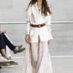 Marc Cain Frühjahr Sommer 2026 Kollektion – weisses Maxi-Ensemble mit Korallen-Print, braunem Ledergürtel und ovaler Sonnenbrille, Berlin Fashion Week