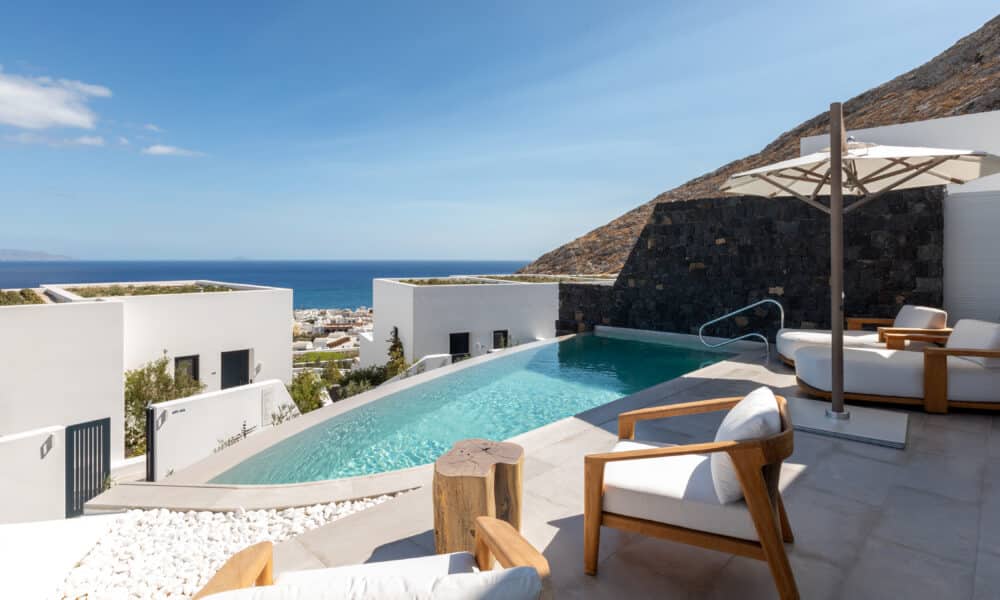 Sandblu Santorini – Blu Infinity-Pool mit Liegedeck, Blick auf die Ägäis und den Mesa Vouno im Abendlicht