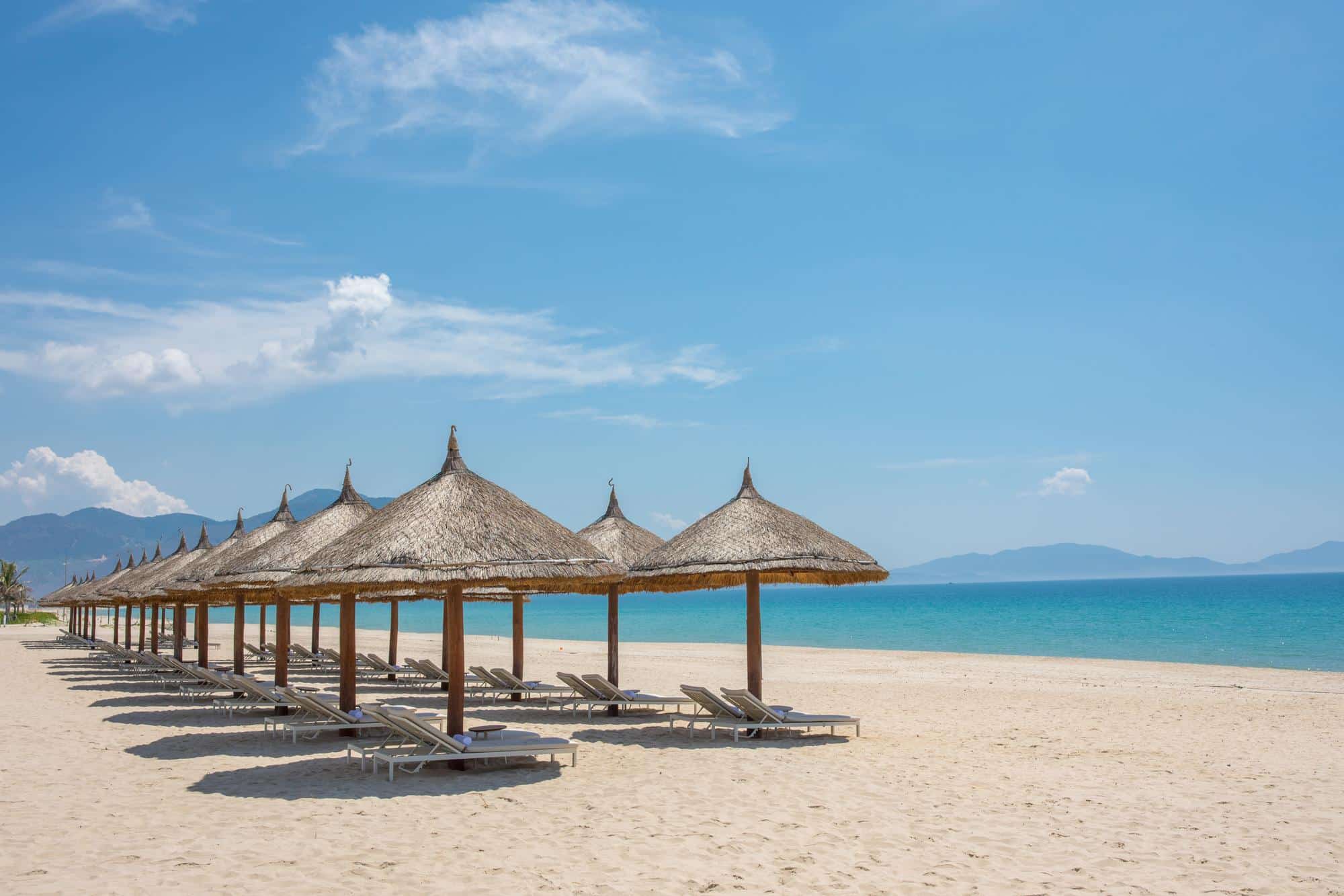 Am Long Beach der Halbinsel Cam Ranh säumen strohgedeckte Schirme den weissen Sandstrand am Südchinesischen Meer (Quelle: zvg).