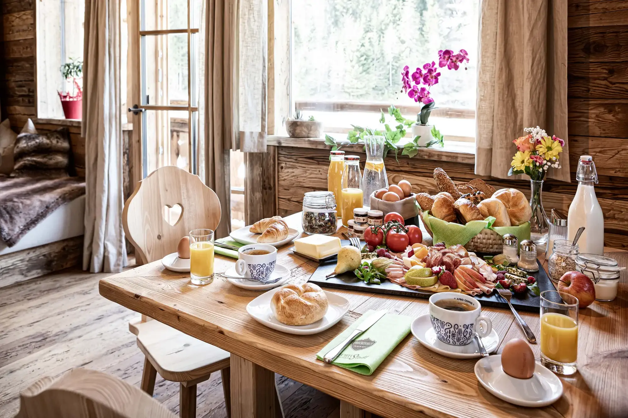 Mehrgenerationenurlaub Chalet: 8 Luxus-Lodges im Prechtlgut Ohne Dresscode und feste Zeiten versammelt sich die Familie am grossen Holztisch zum gemeinsamen Frühstück (Quelle: Bergdorf Prechtlgut).