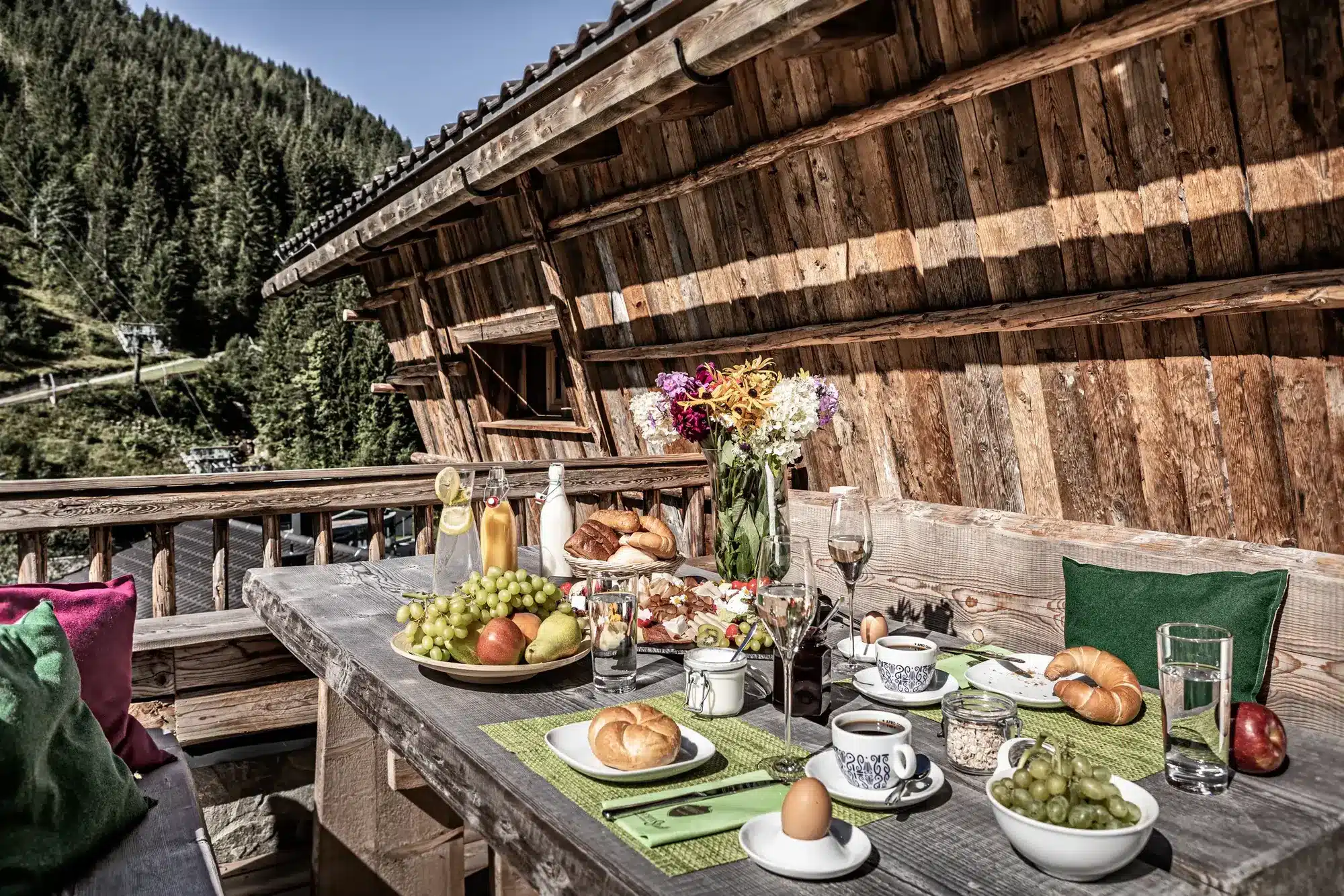 Mehrgenerationenurlaub Chalet: 8 Luxus-Lodges im Prechtlgut Das Frühstück mit regionalen Produkten wird zur Wunschzeit diskret direkt auf der eigenen Terrasse serviert (Quelle: Bergdorf Prechtlgut).