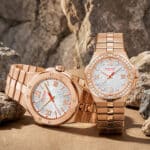 Die luxurioesen Alpine Eagle Uhren von Chopard aus Rosegold glaenzen vor der schroffen Textur einer naturbelassenen Felswand.