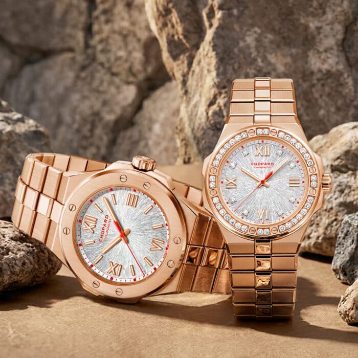 Die luxurioesen Alpine Eagle Uhren von Chopard aus Rosegold glaenzen vor der schroffen Textur einer naturbelassenen Felswand.