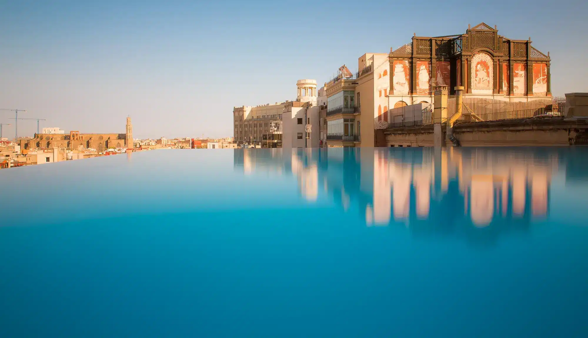 Historische Architektur aus dem Jahr 1926 trifft auf den modernen Infinity Pool an der Via Laietana. (Quelle: Grand Hotel Central Barcelona)