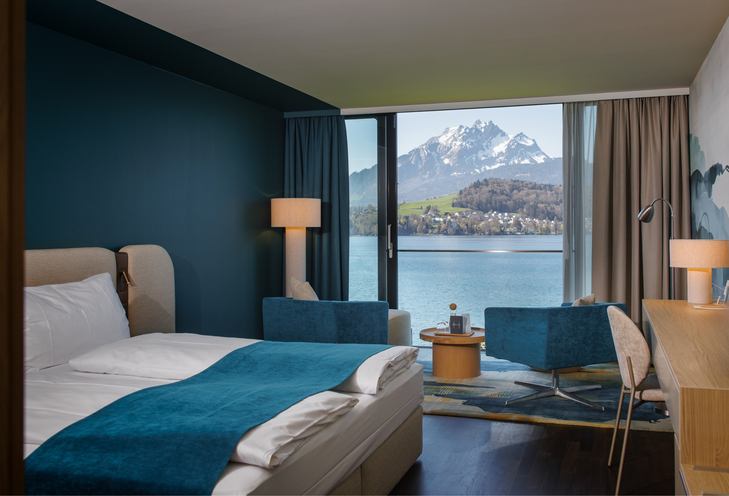 Die neuen Deluxe Zimmer der HERMITAGE Lake Lucerne verbinden tiefblaue Farbwelten mit direktem Blick auf den Vierwaldstättersee und den Pilatus (Quelle: zvg).