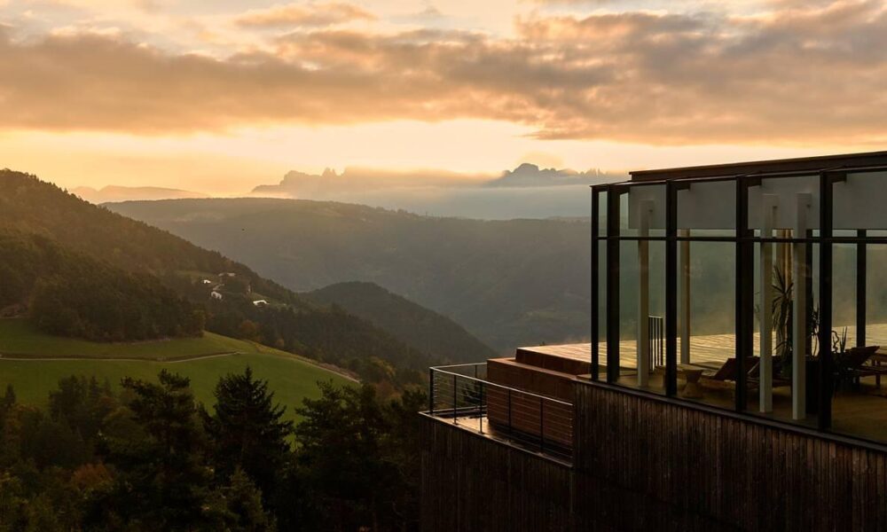 Longevity Retreat Südtirol: Hotel Saltus in Jenesien mit Panoramafenstern über dem Etschtal und den Dolomiten im Abendlicht