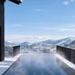 Vom beheizten Aussenpool reicht die freie Sicht weit über das verschneite Salzachtal bis zu den Hohen Tauern. (Quelle: ROSENSTOA Premium Chalets)